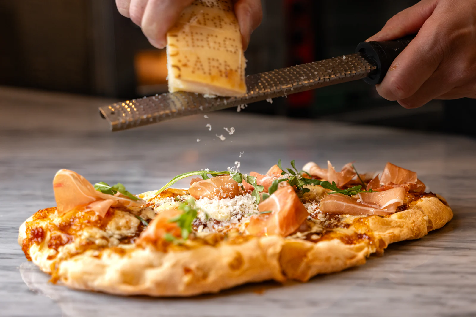 Wood-fired pizza finished with grated cheese