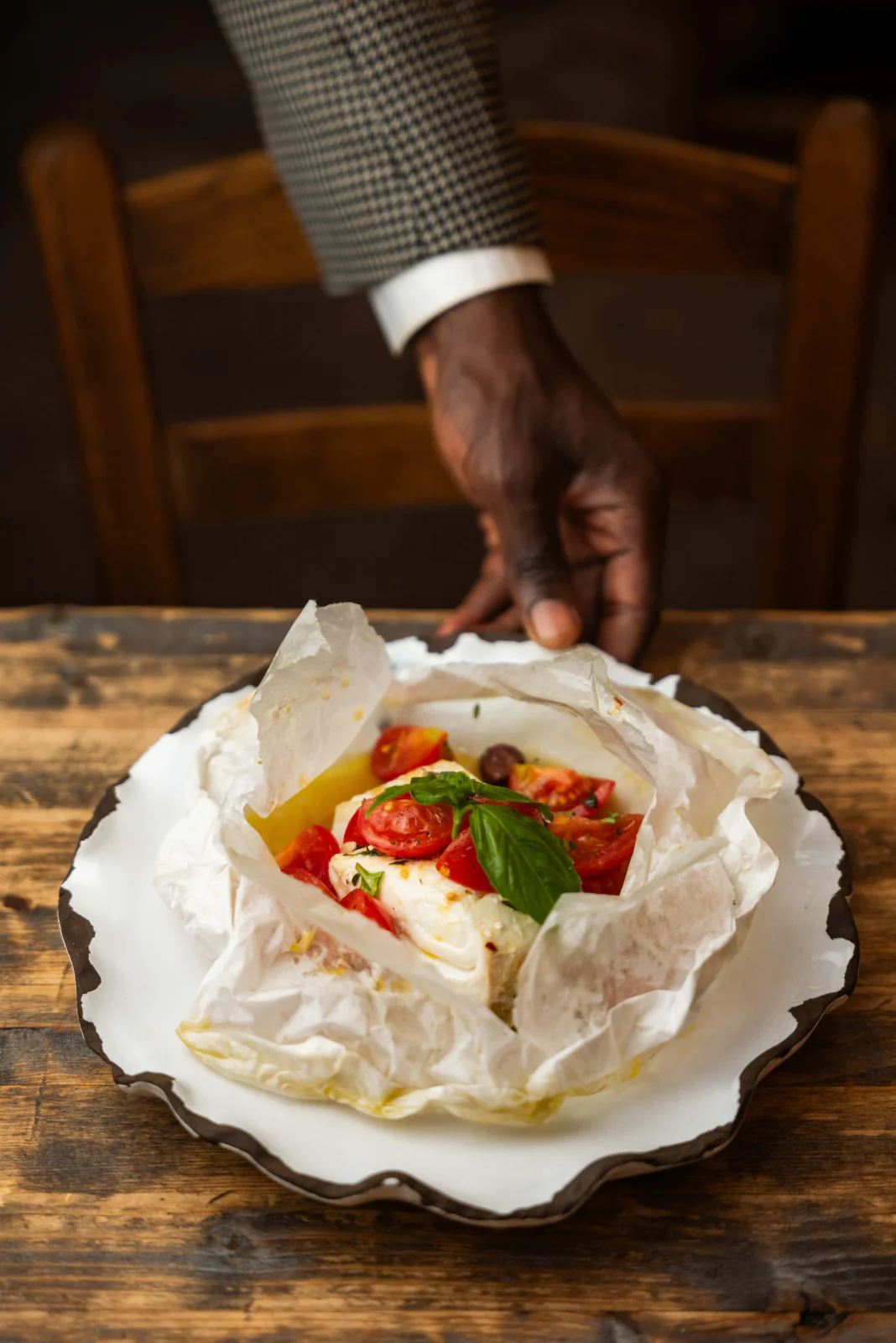 Fish baked in parchment with tomato and basil